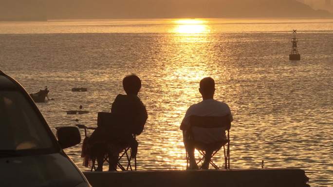 清晨一对夫妇看大海日出