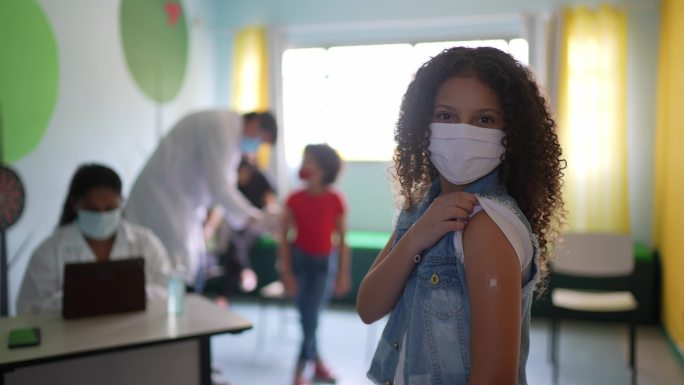 一个小女孩接种疫苗后露出手臂的肖像