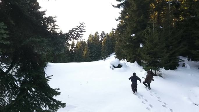 两个猎人拿着步枪在雪地森林里散步