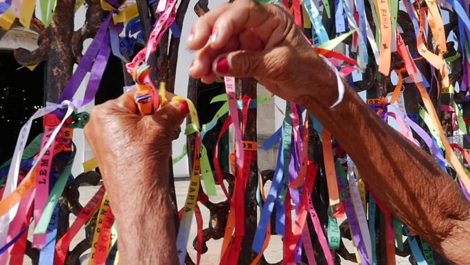 巴伊亚州萨尔瓦多的邦菲姆主教堂上绑着丝带的女性双手