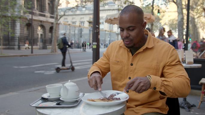 黑人在路边咖啡馆吃法国早餐