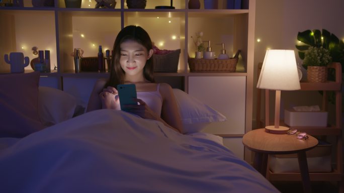 女人在床上使用智能手机