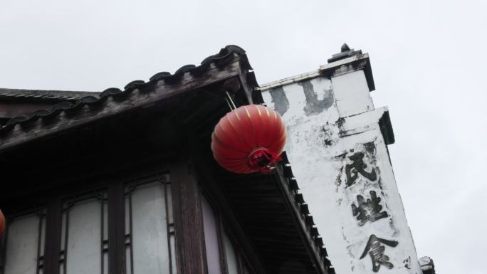 雨天大风吹着老房子一角的红灯笼在飘荡