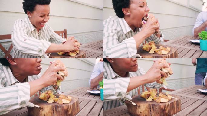 一名非洲裔美国中年妇女在餐厅吃汉堡