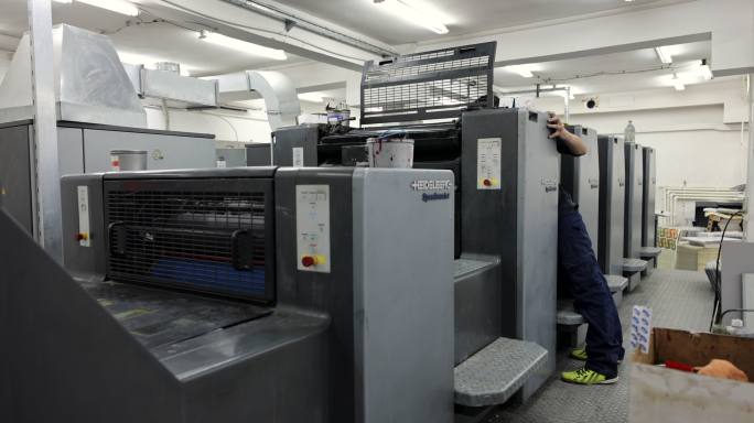 印刷厂工人，启动自动印刷机