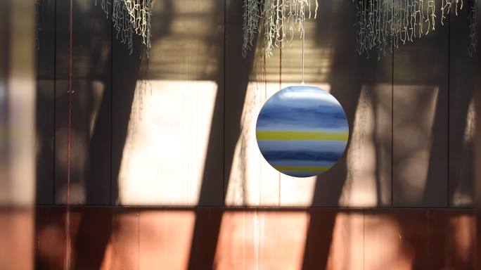 一个蓝色装饰球在微风中悠悠地晃动形似星球