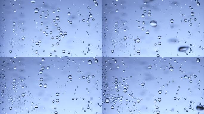 苏打水的宏观照片：水中的各种气泡在蓝色背景上升起