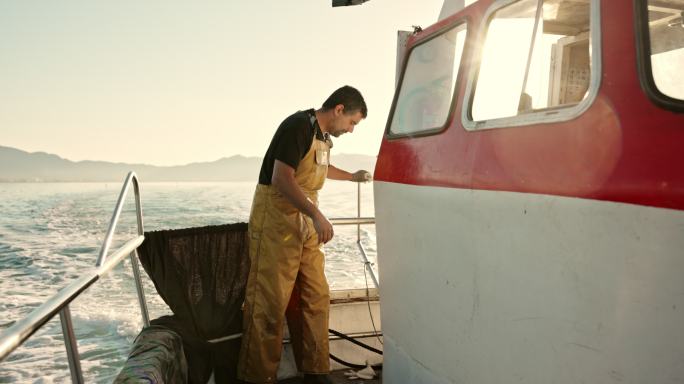 独立渔民在船上摘下工作手套