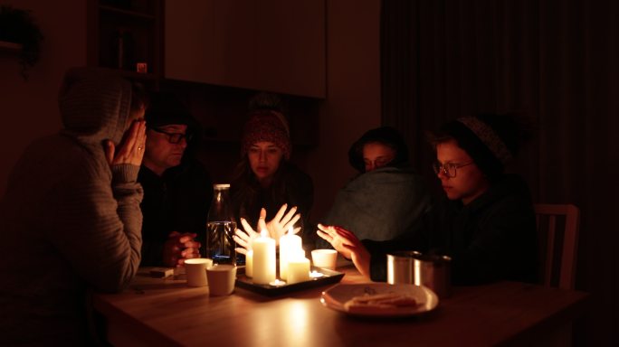 停电期间，一家人坐在蜡烛旁。