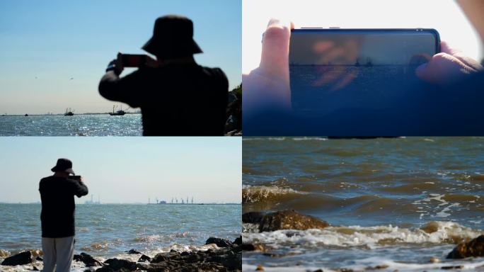 海边用手机拍摄开海的男人