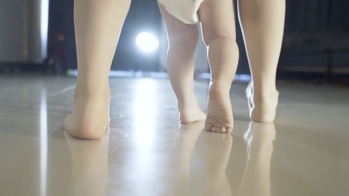 婴儿步履蹒跚学走路温馨婴儿在妈妈搀下学步