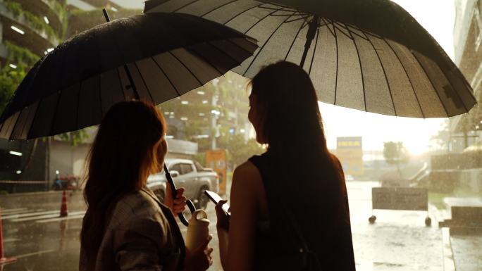 大雨中，两名亚洲妇女正在回家的路上。