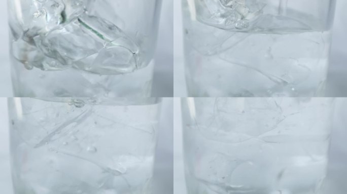 以慢动作将水倒入冰玻璃中。