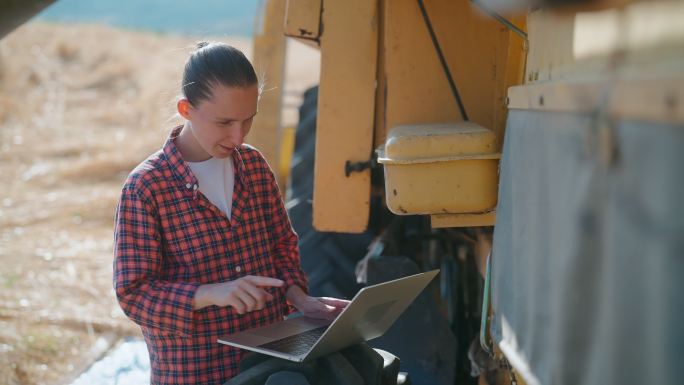 两名多民族女农民在农田里使用笔记本电脑