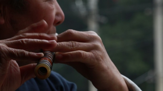 老人皱纹双手演奏传统乐器横笛笛子特写实拍