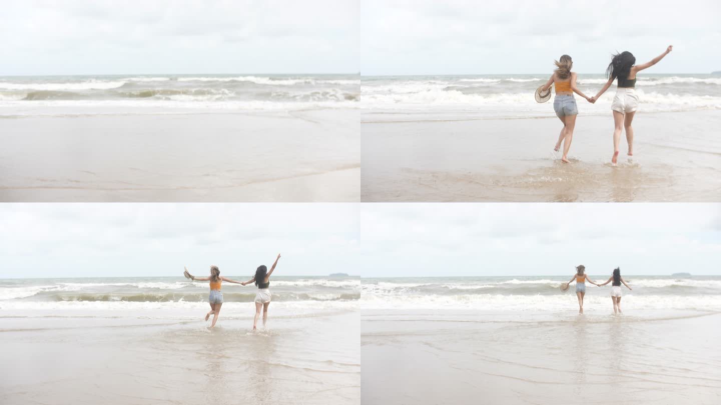 两个女人在海滩上享受和奔跑，手牵着手跑进大海