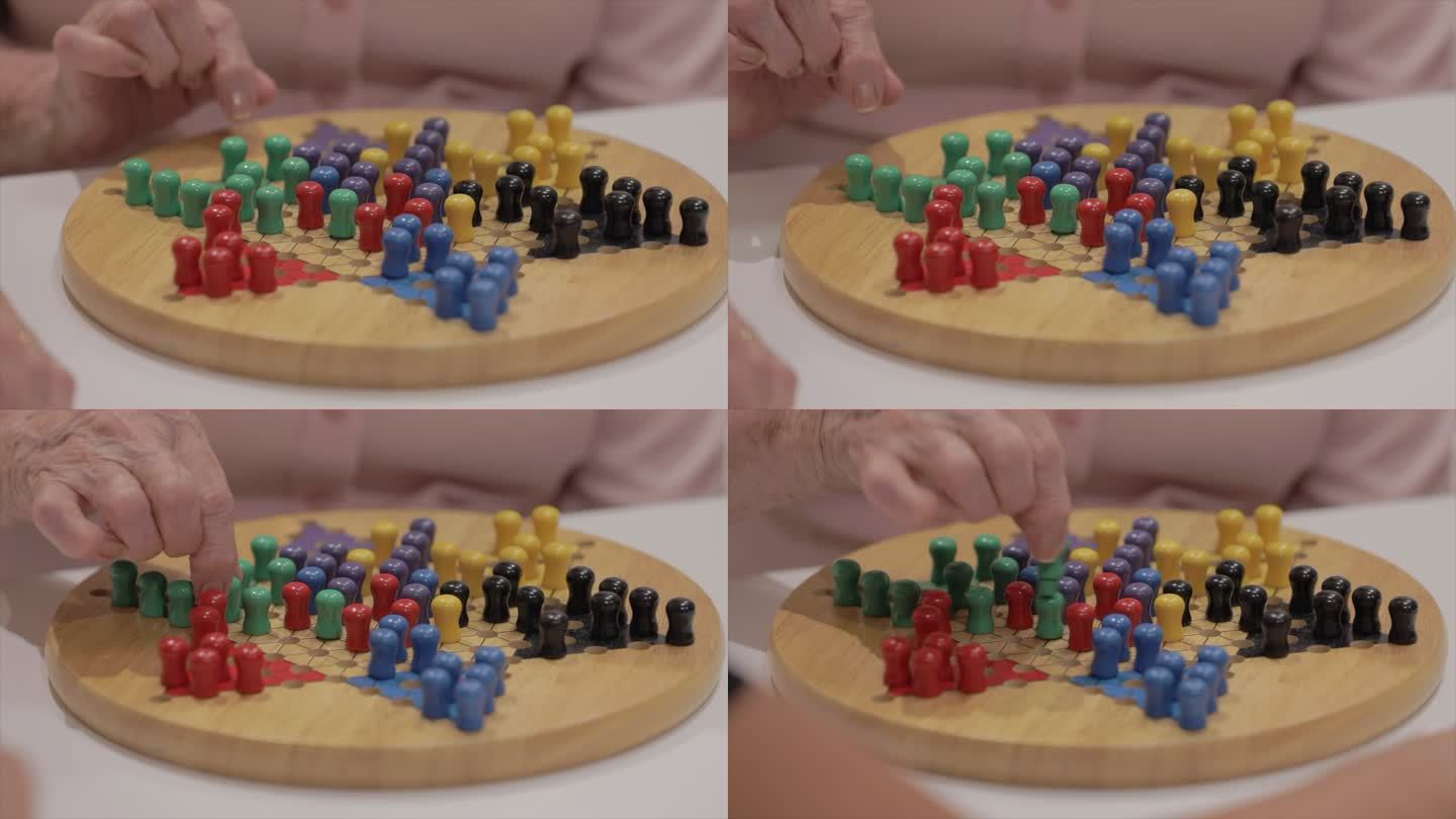 老年妇女玩中国跳棋棋盘游戏