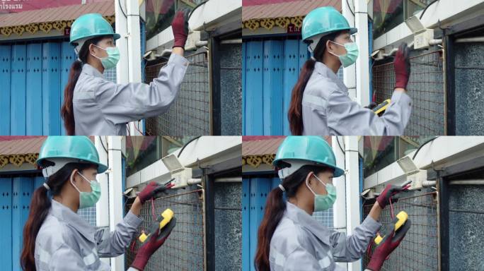 亚洲女技术员检查员检查开关插头中的电力。安全女性测量电压