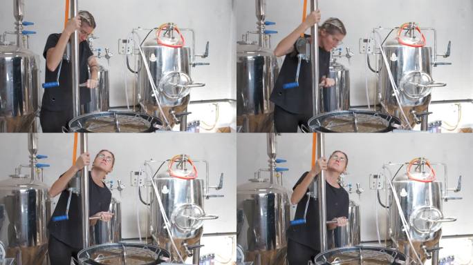 酿酒大师正在准备自动不锈钢罐，以将大麦从罐中取出。