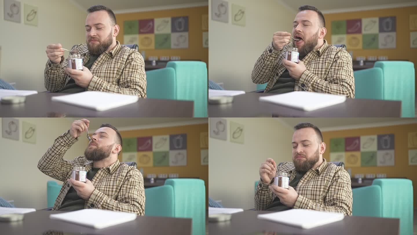 在慢动作视频中，男性在工作场所享受美味佳佳布丁