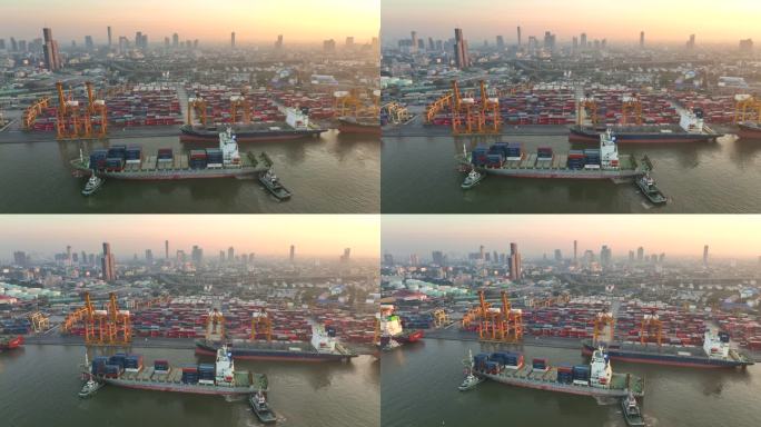 在泰国曼谷日出的场景中，无人机拍摄了一艘货船停靠在码头上，起重机吊杆下降到位，卸下集装箱
