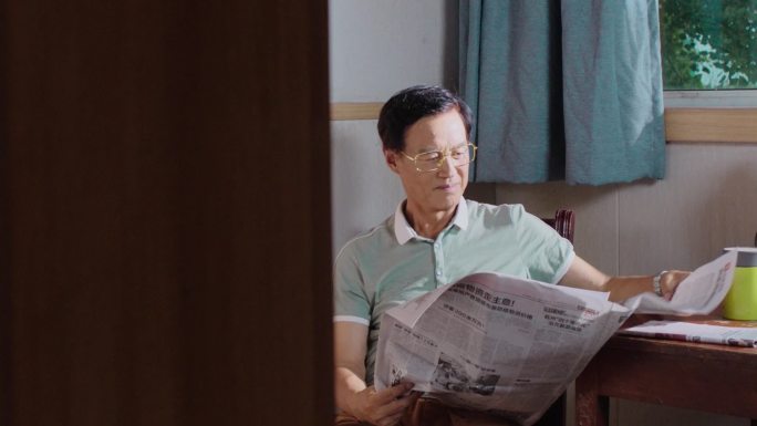 老年人休闲在家看报纸