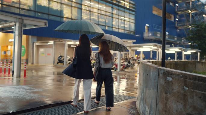 大雨中，两名亚洲妇女正在回家的路上。