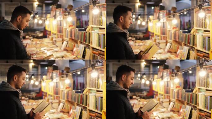一个年轻人在二手书店里看旧书，在波托贝罗路跳蚤市场的一个市场摊位上出售复古书籍