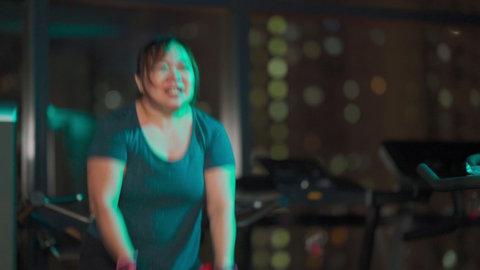 身体积极的亚洲中国中年女性晚上在健身房练习战斗绳
