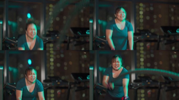 身体积极的亚洲中国中年女性晚上在健身房练习战斗绳