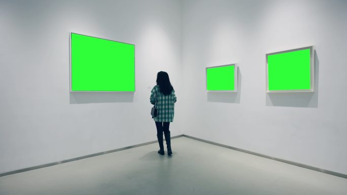 一位年轻女子在美术馆里看着绿色的画框