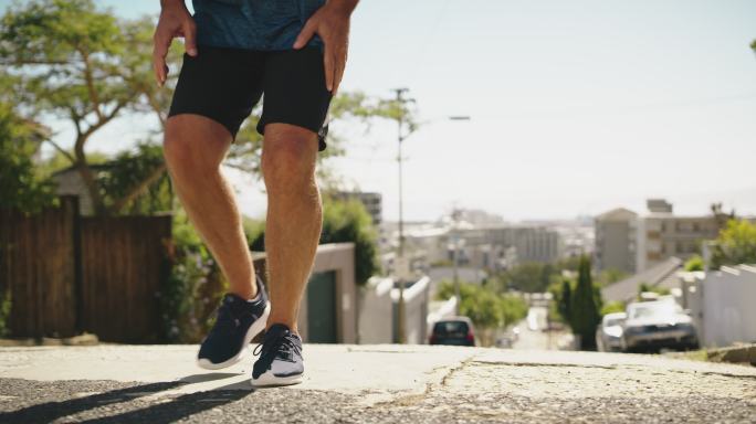 一位膝盖疼痛的老年男子，在例行锻炼时在户外跑步。有运动损伤和关节或腿部无力的成年男子特写镜头