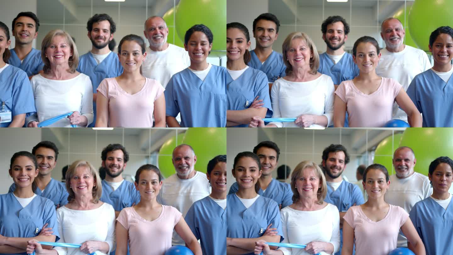一组患者和不同的治疗师，在物理康复中心面对镜头微笑