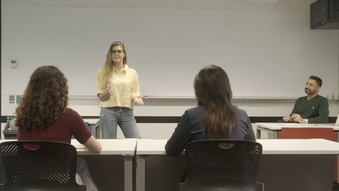 女大学生在课堂上向不同的年轻成年学生群体展示