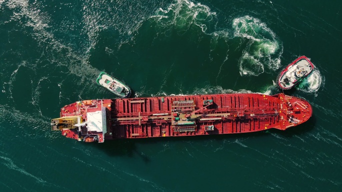集装箱船系泊到码头的鸟瞰图，从小船推动，货船停靠在港口，从港口的船上卸载和装载集装箱，港口的集装箱船