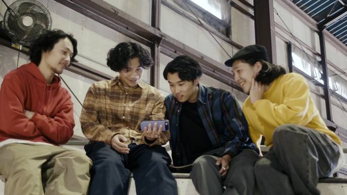 一群日本男孩在智能手机上观看视频（慢动作）