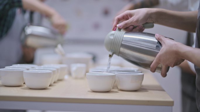 3名专业亚裔中国男咖啡师，品级师，将热水倒入陶瓷咖啡杯，准备咖啡杯，咖啡质量测试