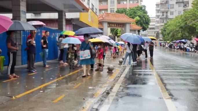 学生放学家长冒雨接小孩子打着雨伞接小学生