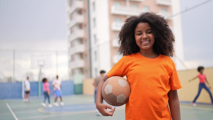 一个女孩在运动场上拿着球的肖像