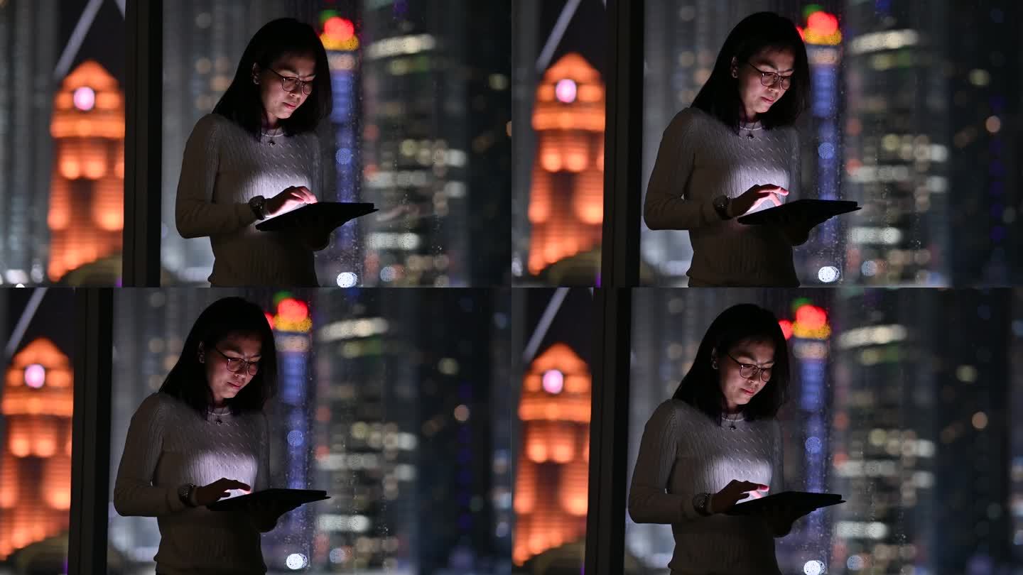 一位亚洲女商人晚上在数字平板电脑上在线工作