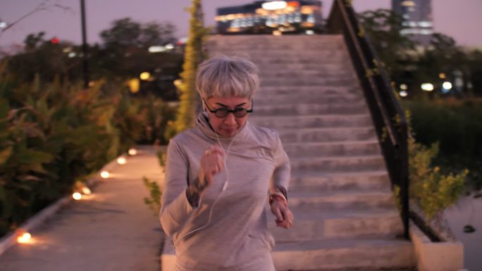 老年妇女在城市里夜间跑步