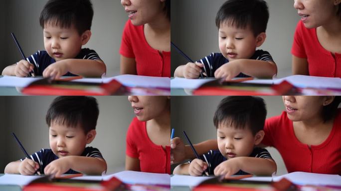 亚洲华人母亲在办公室教她可爱的小男孩绘画艺术