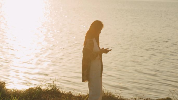 女孩湖边玩手机