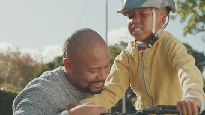 一个英俊成熟的男子在户外教儿子骑自行车的4k视频片段
