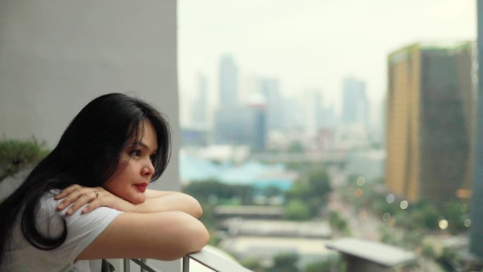 悲伤的亚洲女人在阳台上