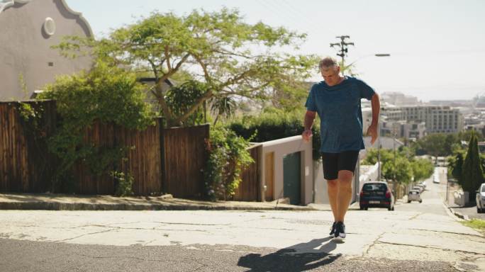 一位膝盖疼痛的老年男子，在例行锻炼时在户外跑步。一个有运动损伤和关节或腿部无力的成熟男人