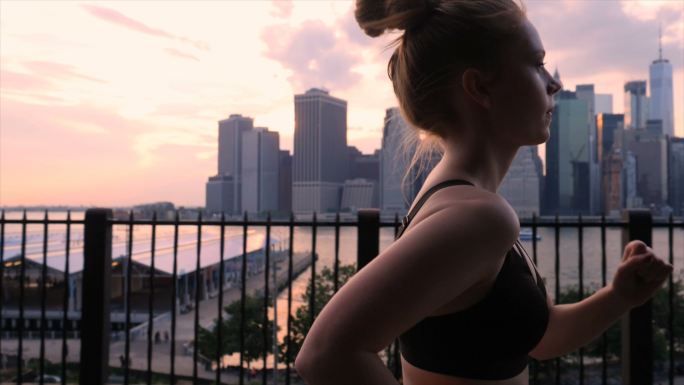 一位年轻女子在纽约市海滨夕阳下锻炼