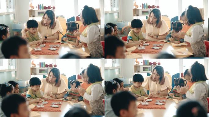 亚洲华人蒙台梭利幼儿园女教师在课堂上指导学生绘画