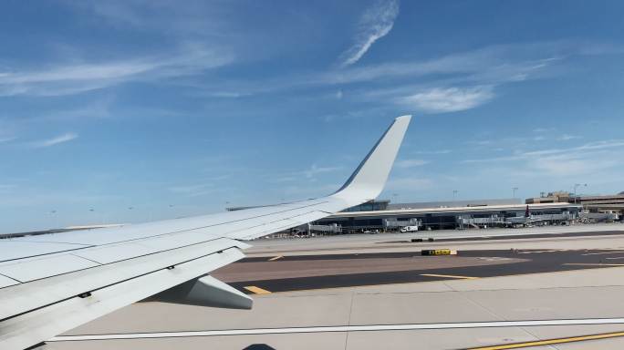 在亚利桑那州凤凰城的凤凰城天空港国际机场，在一个阳光明媚的日子里，一架商用飞机从机翼上起飞