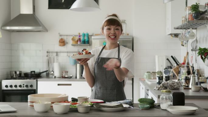 日本女影响者和厨师向她的虚拟烹饪课观众展示temaki寿司卷